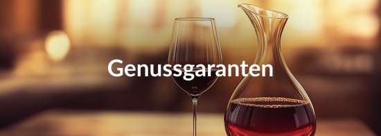  Ein mit Rotwein gefülltes Weinglas und eine mit Rotwein gefüllte Karaffe im goldenen Ambiente mit der Aufschrift &quot;Genussgaranten&quot;